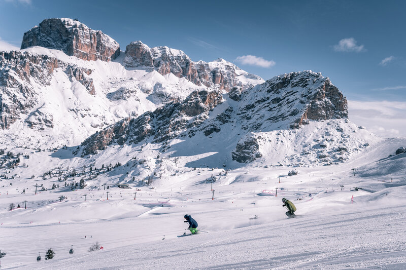 Skiarea Belvedere - Col dei Rossi - Canazei | © Patricia Ramirez  - Archivio immagini ApT Val di Fassa Coppia di amici scia sulle piste della skiarea Belvedere di Canazei. Sullo sfondo Sass Becé e Sass Pordoi | © Patricia Ramirez  - Archivio immagini ApT Val di Fassa