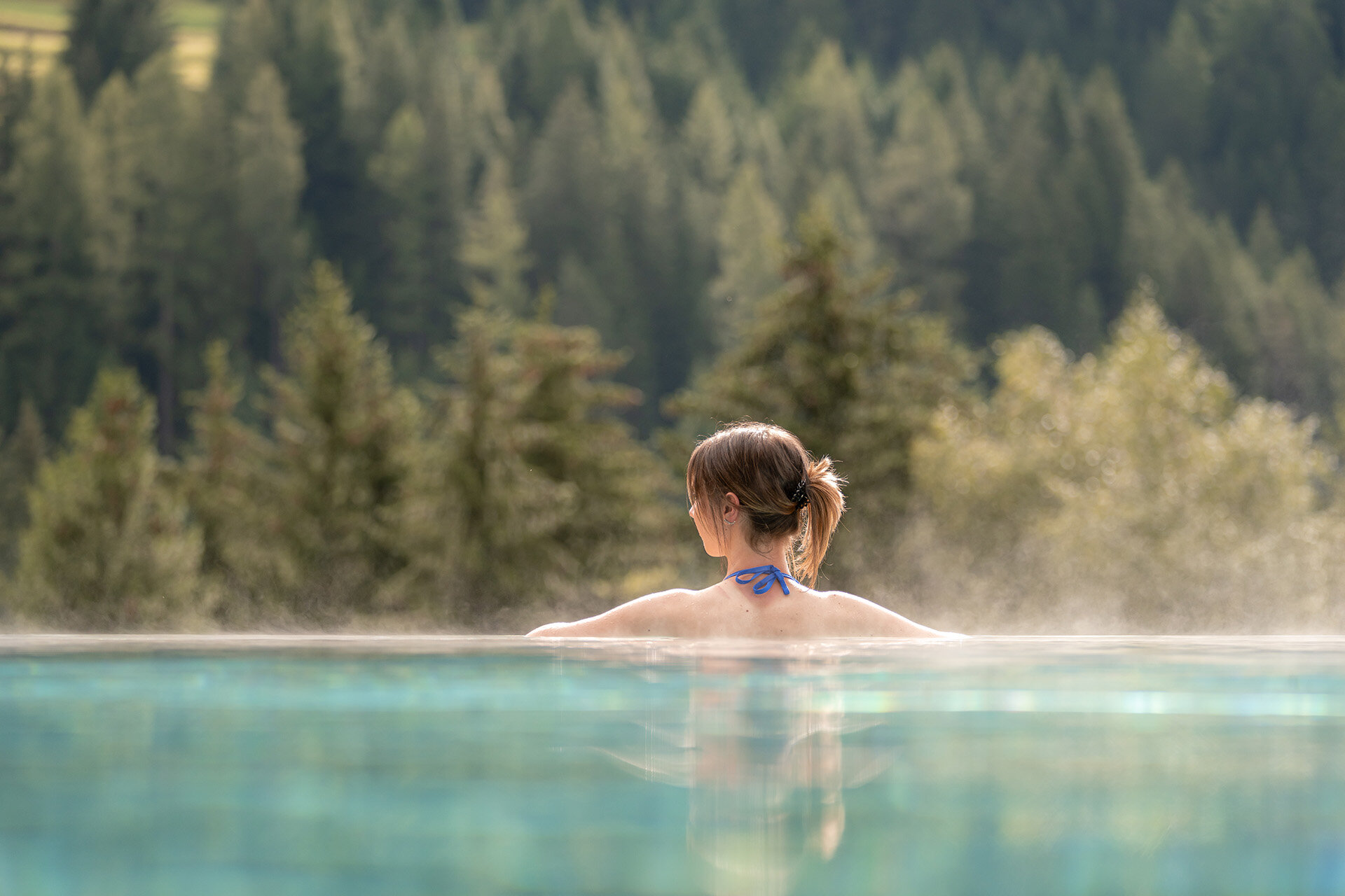 Benessere in Val di Fassa | © Mattia Rizzi - Archivio Immagini ApT Val di Fassa  Ragazza di spalle in una piscina esterna con vista sulle Dolomiti in Val di Fassa | © Mattia Rizzi - Archivio Immagini ApT Val di Fassa